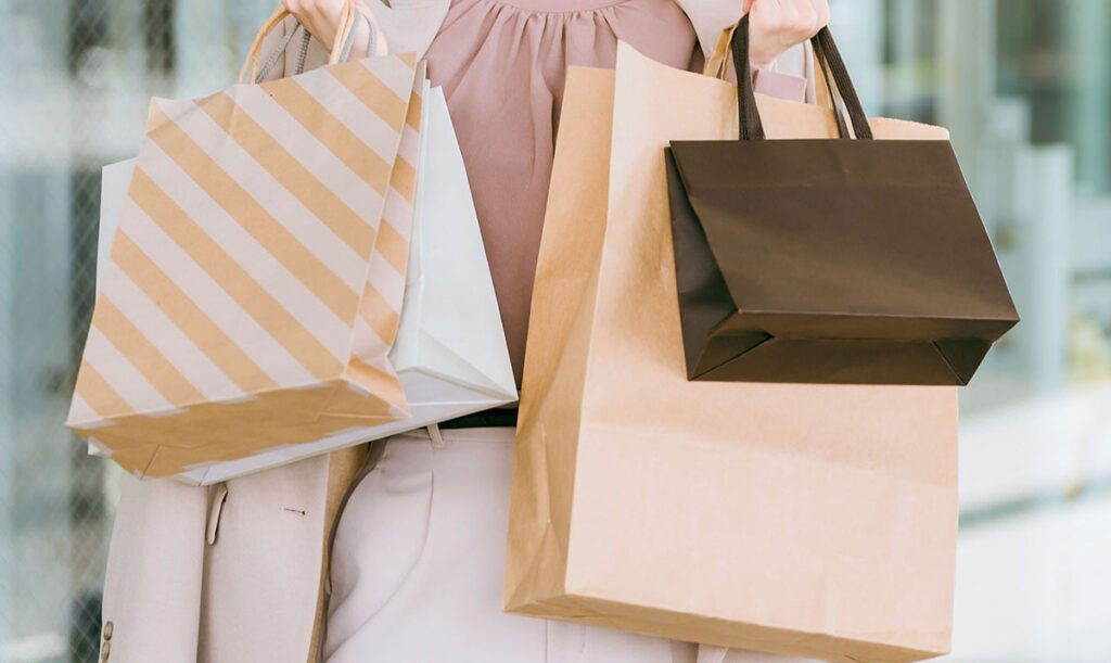 浮気で買い物が長くなり紙袋をもっている女性