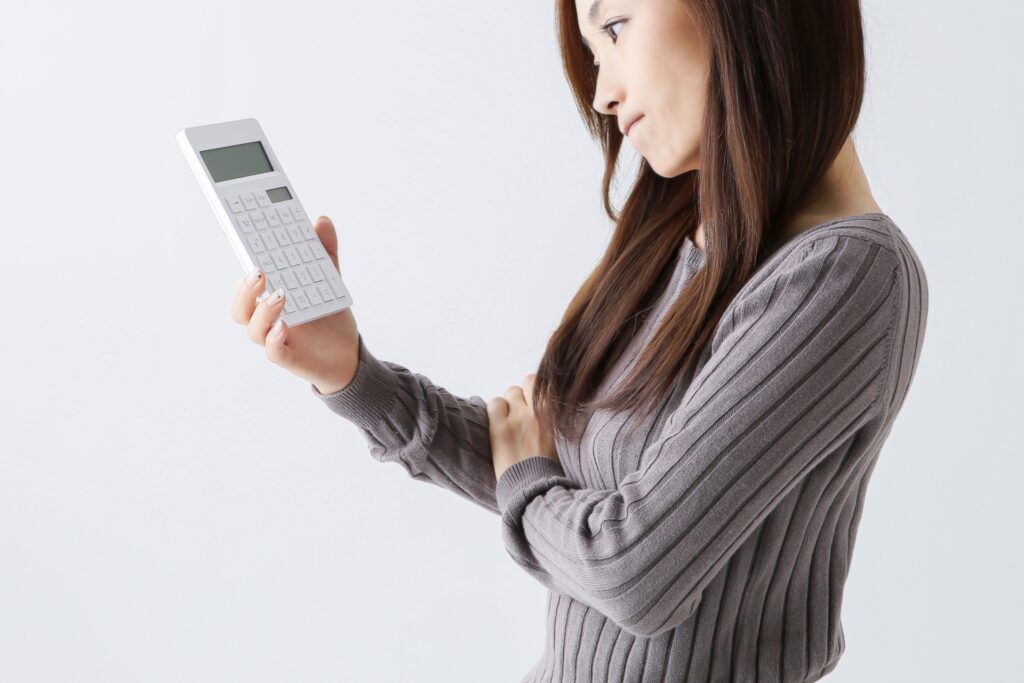 浮気調査の費用相場に悩む女性と電卓｜宇都宮で探偵に依頼する料金イメージ